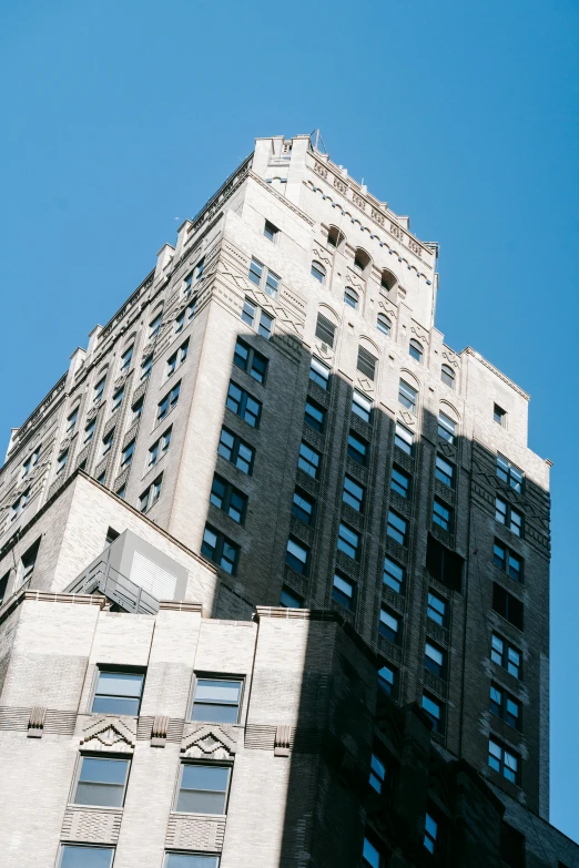 a tall building sitting in the middle of a city, an art deco sculpture, top - side view, low quality photo, fan favorite, taken in the mid 2000s