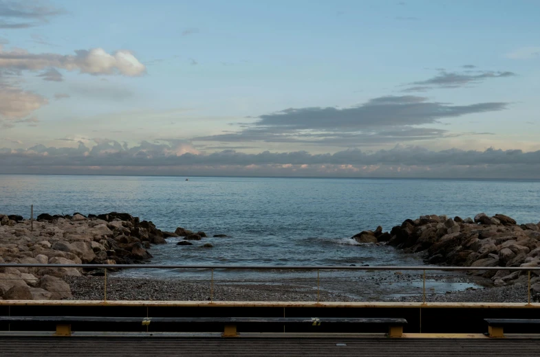 a bench sitting on the side of a road next to a body of water, a portrait, inspired by Thomas Struth, unsplash, gulf of naples, panoramic, medium format. soft light, realistic »