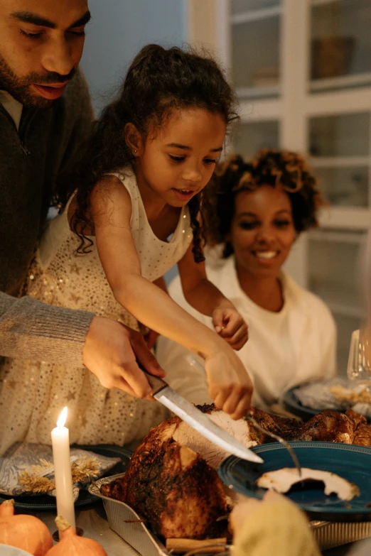 a group of people sitting around a table with food, holding a candle, holding a kitchen knife, holiday season, thumbnail