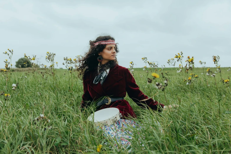 a woman sitting in a field with a frisbee, an album cover, unsplash, renaissance, wearing victorian rags, imaan hammam, cinematic outfit photo, wild flowers