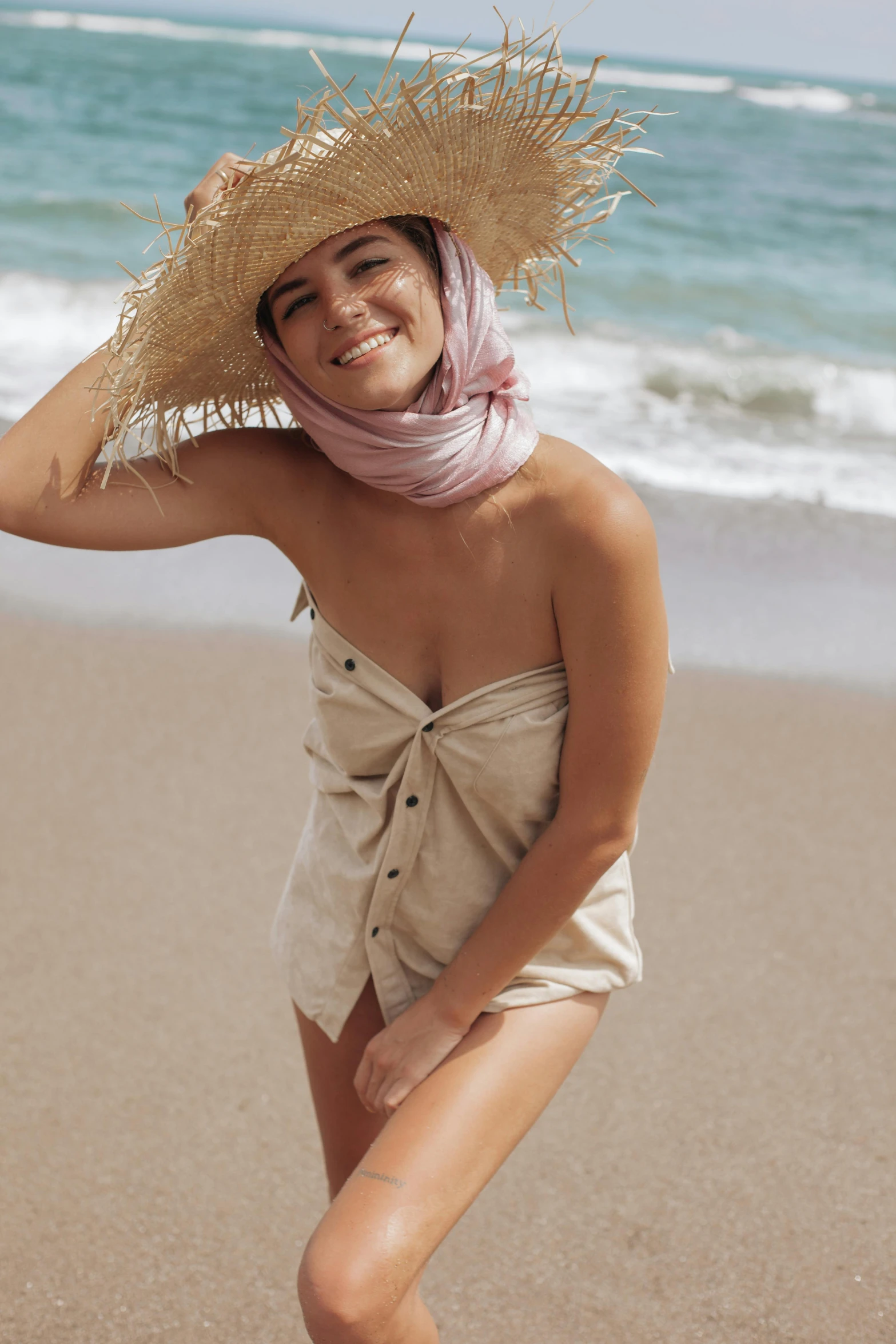 a woman standing on top of a sandy beach, one piece style, natural skin tones, cotton, covered in sand