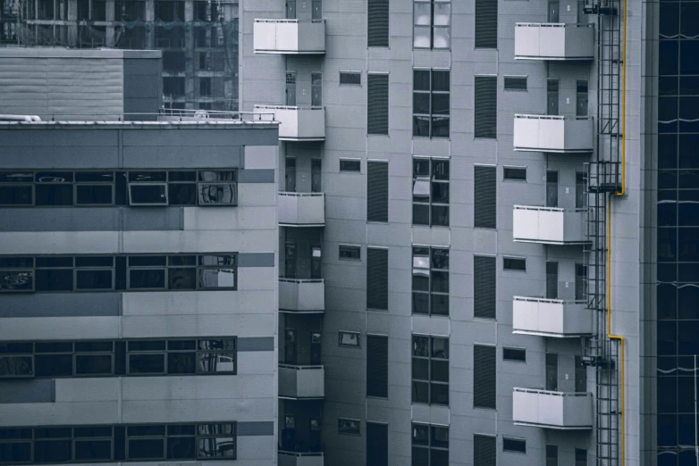 a black and white photo of a tall building, inspired by Elsa Bleda, pexels contest winner, brutalism, blue and grey, soviet apartment buildings, telephoto shot, the place is just really small