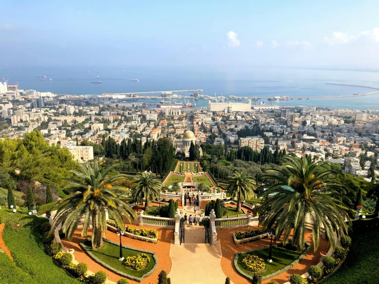 a view of a city from the top of a hill, gardens and fountains, 🚿🗝📝, ocean view, middle eastern