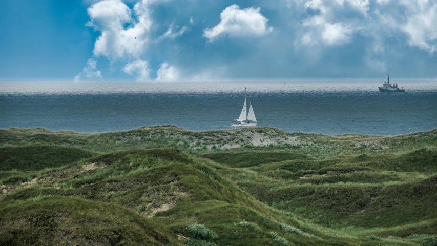 a couple of boats that are in the water, a picture, by Andries Stock, pexels contest winner, magic realism, on dune, grassy hill, sailing boat, thumbnail