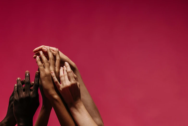 a group of people with their hands in the air, pink and red color scheme, solid background, compassion, lpoty