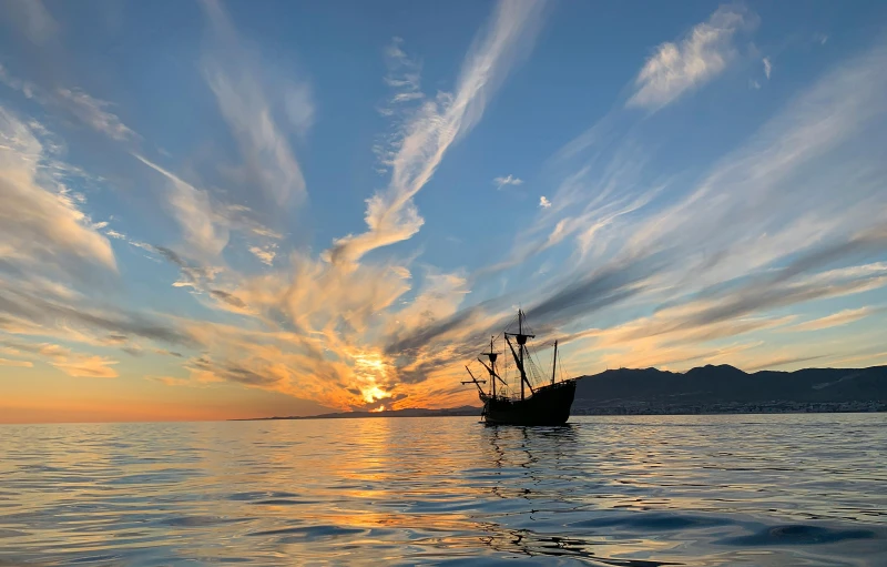 a boat floating on top of a body of water, inspired by Juan de Flandes, unsplash contest winner, renaissance, sunset lighting 8k, pirate, photo on iphone, the city of santa barbara