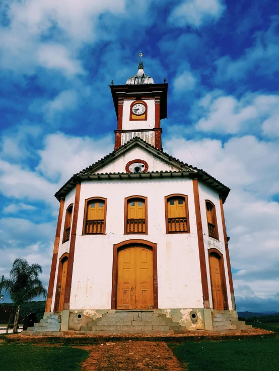 a white and brown building with a clock tower, an album cover, by Matthias Stom, unsplash, quito school, 👰 🏇 ❌ 🍃, countryside, brazilian, shrines