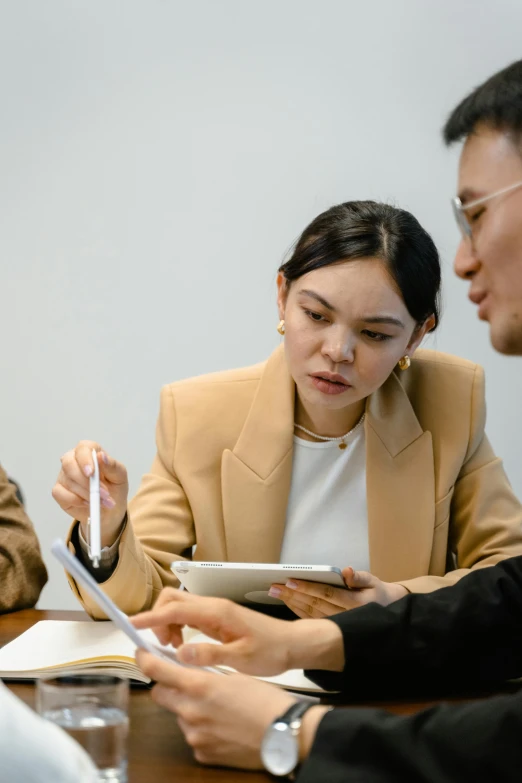 a group of people sitting around a wooden table, woman in business suit, 2 people, ui and ux, asian descent