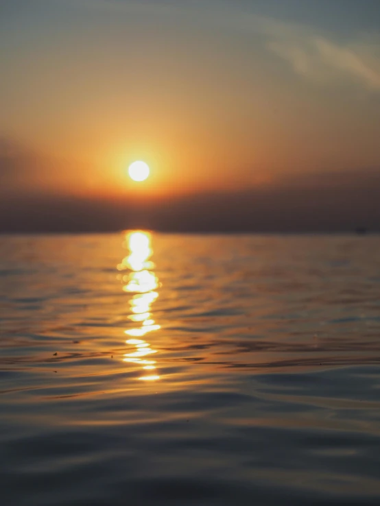 the sun is setting over a body of water, a picture, unsplash, romanticism, close - up photograph, view from the sea, uploaded, unedited