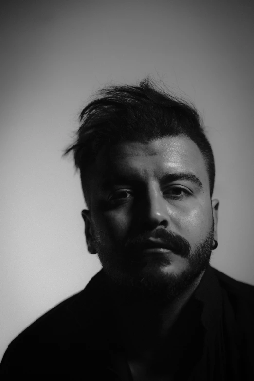 a black and white photo of a man, an album cover, inspired by Paolo Parente, sayem reza, with a small beard, joe gb fenton, androgynous person