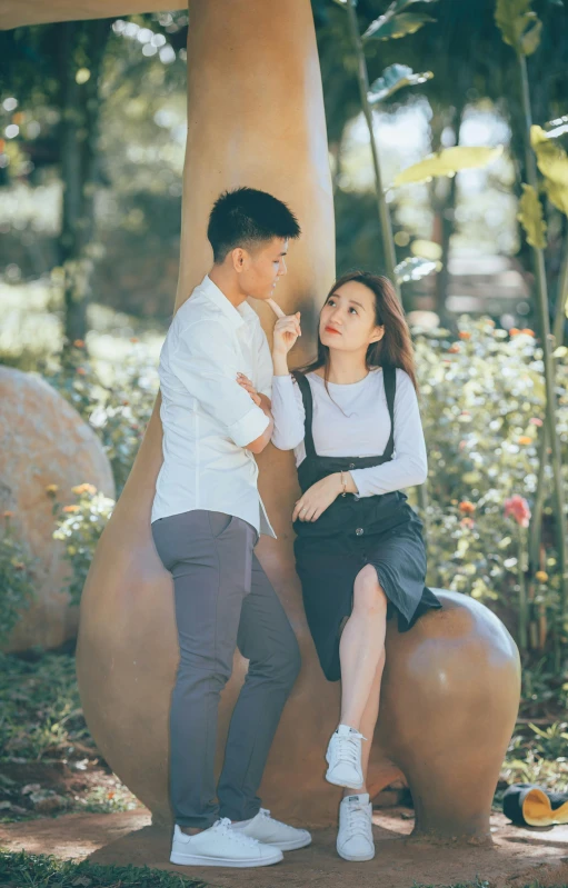 a man and woman standing next to each other in front of a mushroom, by Tan Ting-pho, pexels, realism, sitting under a tree, 15081959 21121991 01012000 4k, flirty, wearing casual clothing