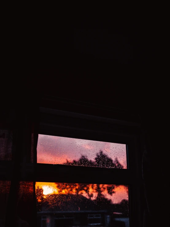 a sunset seen through a window in a dark room, inspired by Elsa Bleda, unsplash contest winner, realism, rainy; 90's photograph, trending on vsco, orange / pink sky, with red haze