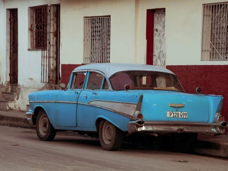 a blue car parked on the side of a street, an album cover, conde nast traveler photo, square, ((blue)), preserved historical