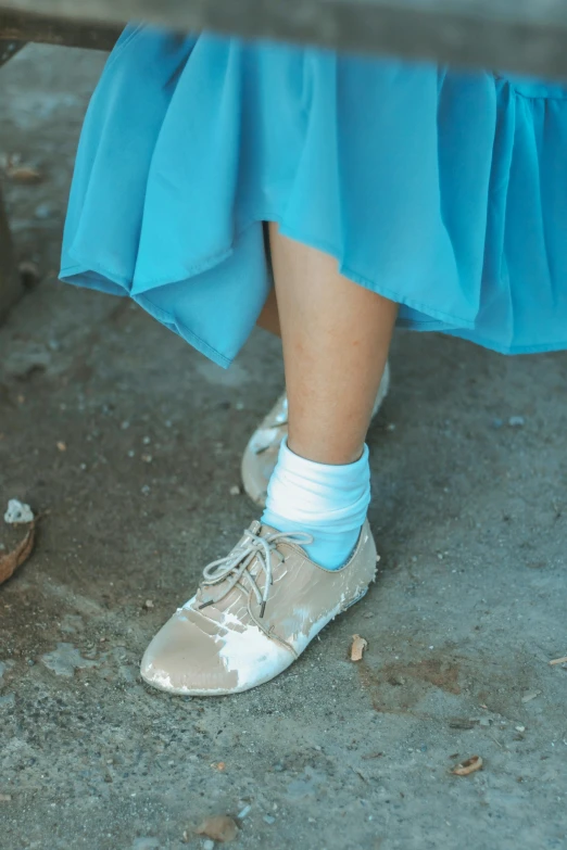 a close up of a person's shoes near a bench, an album cover, by Elsa Bleda, unsplash, renaissance, light blue dress portrait, dressed in a frilly ((ragged)), cream and blue color scheme, concert