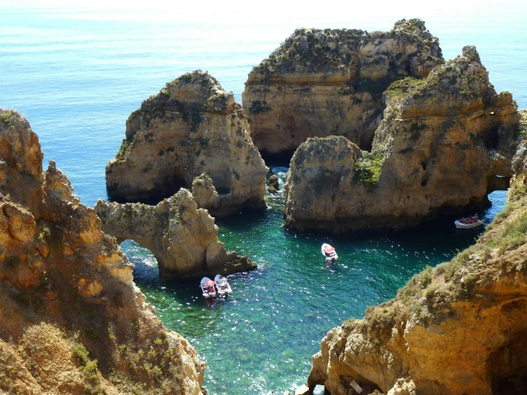 a group of boats floating on top of a body of water, pexels contest winner, renaissance, coastal cliffs, rocha, pools of water, olivia de bernardinis