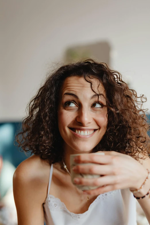 a woman sitting at a table with a glass of wine, a portrait, pexels contest winner, all overly excited, portrait of morning coffee, brown curly hair, happy friend