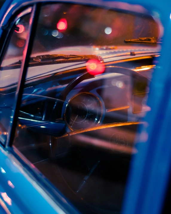 a close up of a car's side view mirror, an album cover, pexels contest winner, retrofuturism, police lights, blue light, 5 0 s aesthetic, slightly colorful