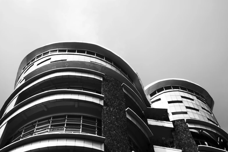 a black and white photo of a tall building, inspired by Ned M. Seidler, beautiful futuristic new delhi, rounded roof, nepali architecture buildings, balconies