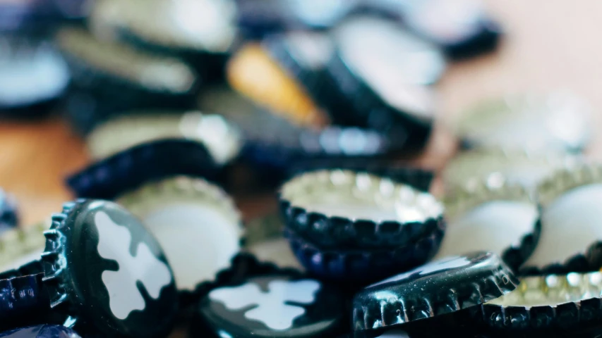 a pile of bottle caps sitting on top of a wooden table, unsplash, bells, te pae, feature, tastes