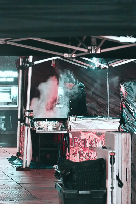 a man standing under a tent with smoke coming out of it, by Robbie Trevino, trending on unsplash, process art, with street food stalls, cold as ice! 🧊, dj set, slightly pixelated