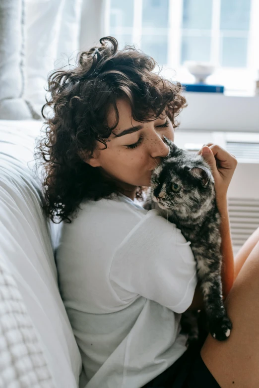 a woman sitting on a couch holding a small dog, pexels contest winner, romanticism, a sick cat laying in a bedroom, with curls, kissing each other, profile image