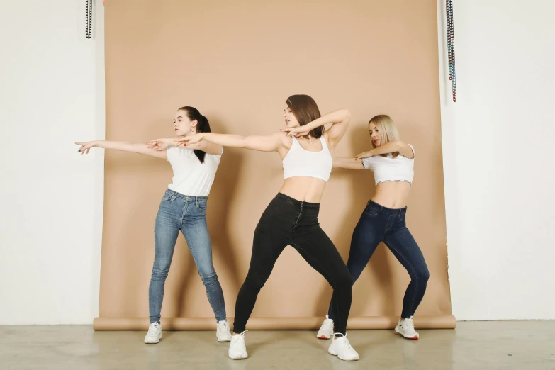 a group of women standing next to each other, trending on pexels, arabesque, synthetic curves striking pose, jeans and t shirt, stretch, upper body image