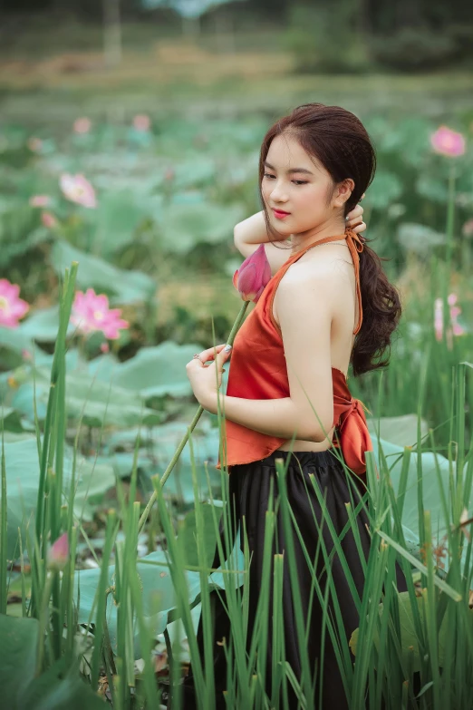 a woman standing in a field of flowers, inspired by Cui Bai, standing gracefully upon a lotus, wearing red tank top, dang my linh, nymphaea