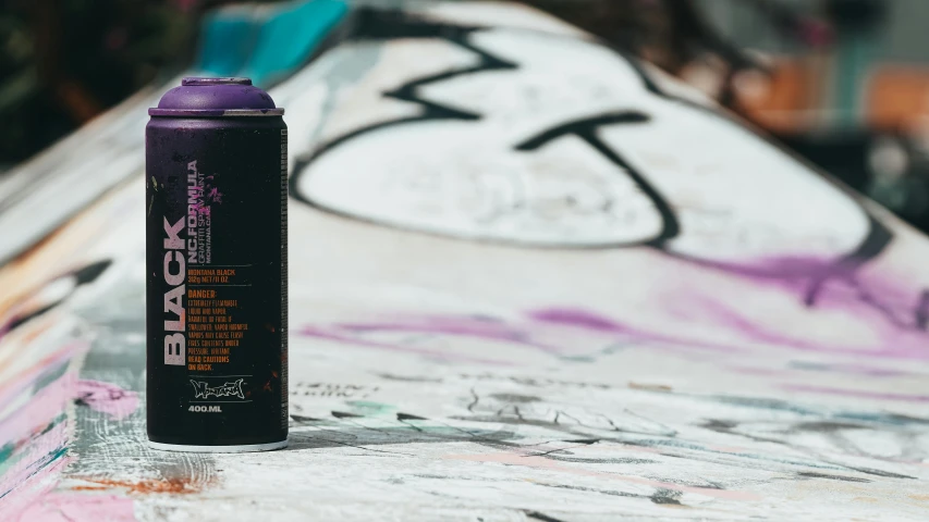 a spray can sitting on top of a skateboard covered in graffiti, pexels contest winner, graffiti, some purple and orange, detailed product image, black paint, can of paint