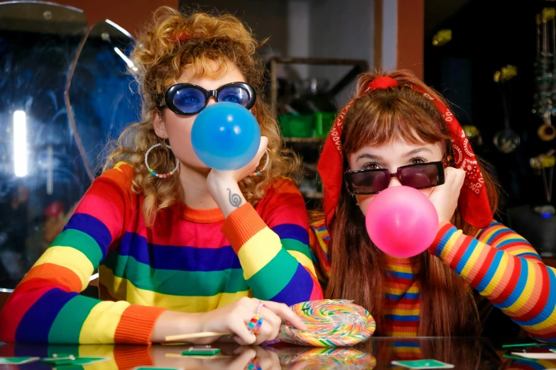 two women blowing bubbles while sitting at a table, a portrait, shutterstock, rainbow clothes, retro and 1 9 8 0 s style, games, twiddle a plopple