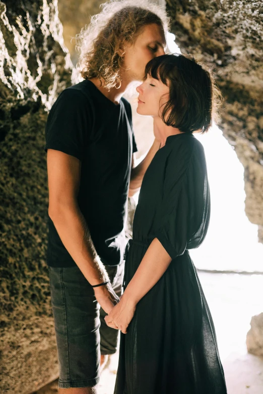 a man and woman standing next to each other in a cave, pexels contest winner, romanticism, shag hair, flirting, on beach, lachlan bailey