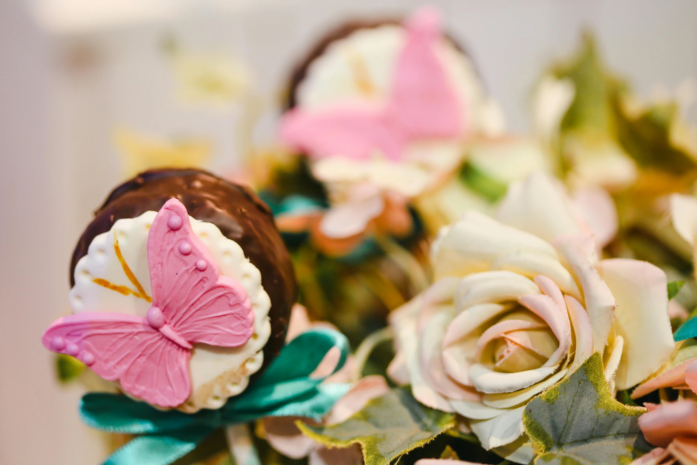 a close up of a bouquet of flowers with a butterfly on it, a still life, by Julian Allen, pexels, covered with pink marzipan, chocolate art, thumbnail, wedding