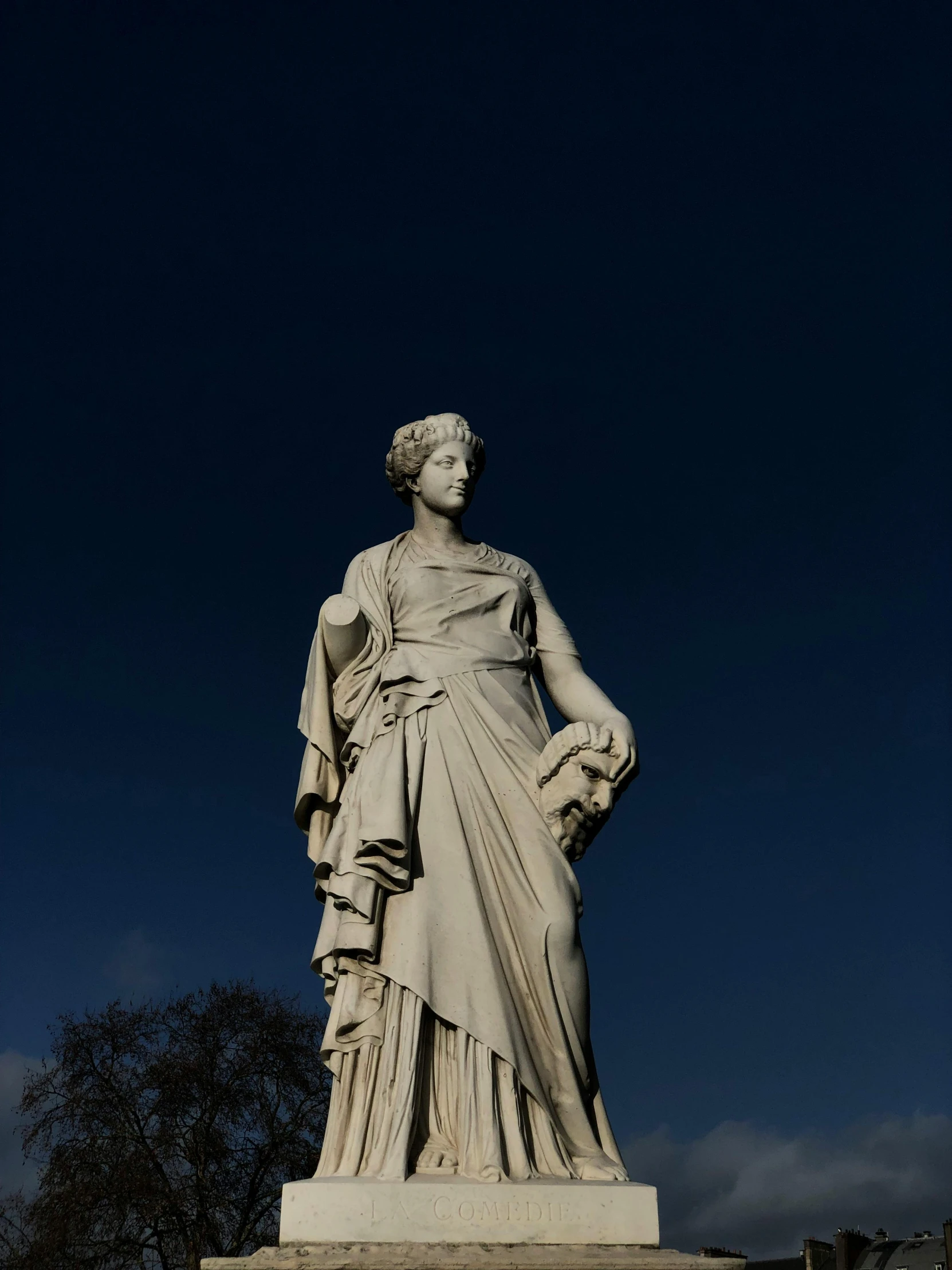 a statue of a woman standing in front of a building