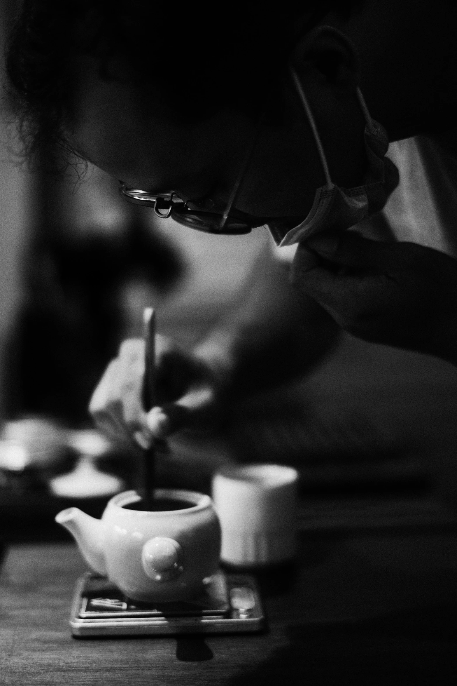 a person sitting at a table writing on a piece of paper, a black and white photo, pexels contest winner, process art, tea ceremony scene, teapot : 1, profile picture, porcelain organic