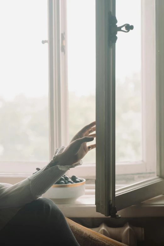 a woman sitting on a couch looking out a window, inspired by Elsa Bleda, pexels contest winner, “berries, hands reaching for her, breakfast, ignant