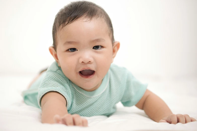 a close up of a baby laying on a bed, shutterstock contest winner, happening, young cute wan asian face, all overly excited, malaysian, grey