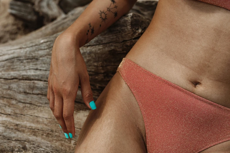 a close up of a person wearing a bikini, a tattoo, inspired by Elsa Bleda, trending on pexels, figuration libre, cinnamon skin color, turqouise, unclipped fingernails, thigh gap