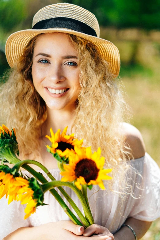 a woman in a hat holding a bunch of sunflowers, pexels contest winner, renaissance, curly blond hair, happy fashion model face, square, midsommar color theme