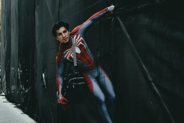 a man in a spider - man suit leaning against a wall, inspired by Adam Dario Keel, pexels contest winner, dressed as a scavenger, andrew garfield, professional cosplay, celebrating