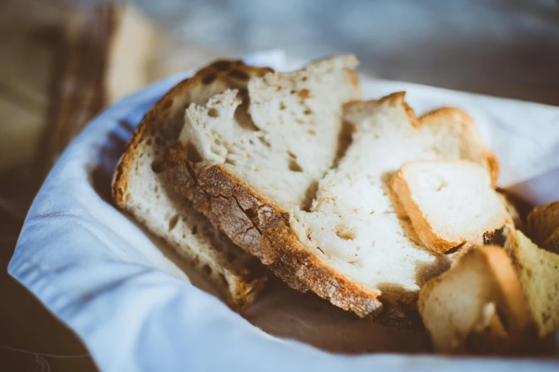 a close up of a piece of bread in a basket, pexels contest winner, white, jen atkin, parchment paper, hot food