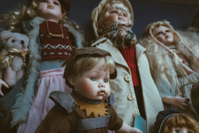 a group of dolls sitting next to each other, by Elsa Bleda, pexels contest winner, antiques, looking up at camera, thumbnail, brown