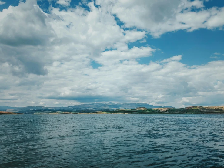 a large body of water under a cloudy sky, by Muggur, unsplash, renaissance, croatian coastline, a photo of a lake on a sunny day, water levels, listing image