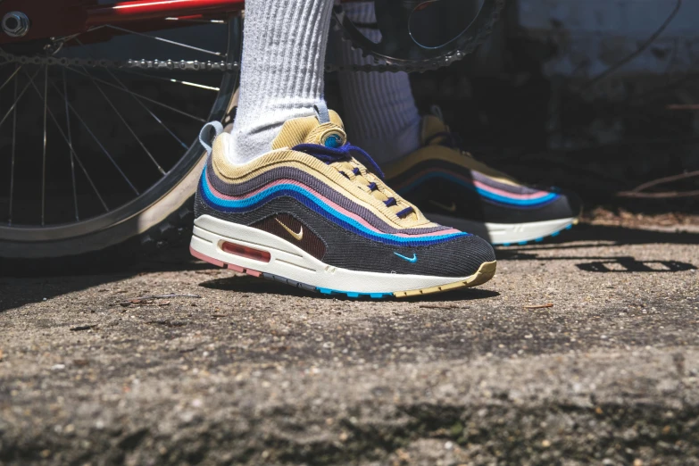 a close up of a person standing next to a bike, nike air max, multicoloured, gold and black blu, a pair of ribbed