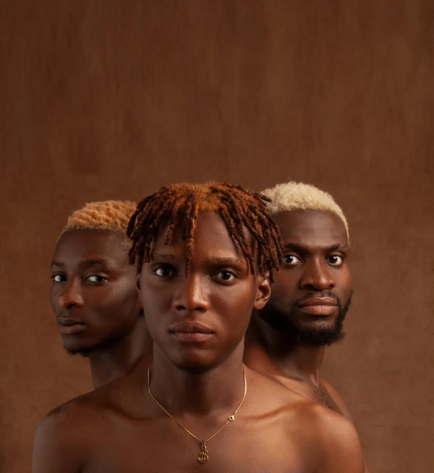 a couple of men standing next to each other, an album cover, by Chinwe Chukwuogo-Roy, trending on pexels, afrofuturism, bleached strong lights, group portrait, the three moiras, with brown skin