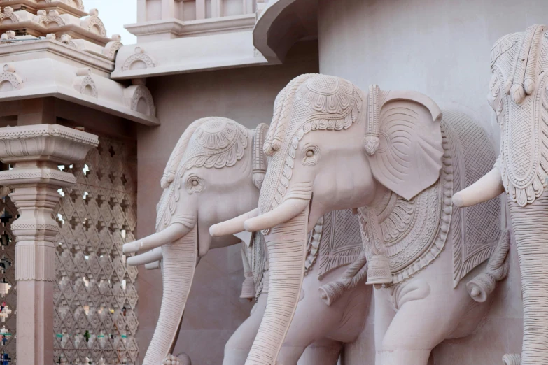 a group of elephants standing next to each other, a marble sculpture, pink marble building, indore, beige, weta studios