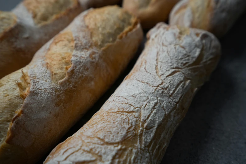 a bunch of bread sitting on top of a table, holding a baguette, detailed product image, close up photo, thumbnail