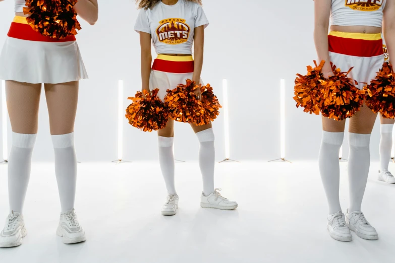 a group of cheerleaders standing next to each other, pexels, sots art, orange light, set against a white background, jets, advertising