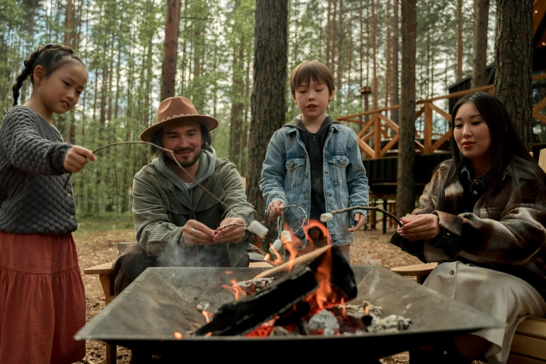 a group of people sitting around a campfire, a portrait, by Jaakko Mattila, pexels contest winner, finn wolfhard, charlie cox, production still, forest picnic