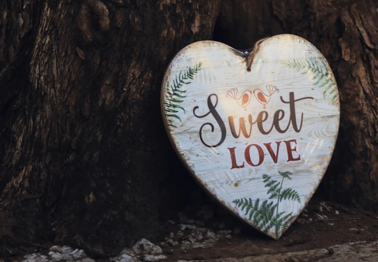 a wooden heart with the words sweet love written on it, a picture, pexels contest winner, paul barson, well decorated, outdoor photo, background image