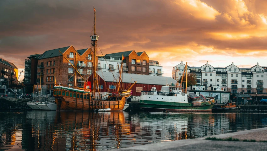 a couple of boats that are in the water, inspired by Tove Jansson, pexels contest winner, reykjavik, warm hues, city docks, dramatic reddish light