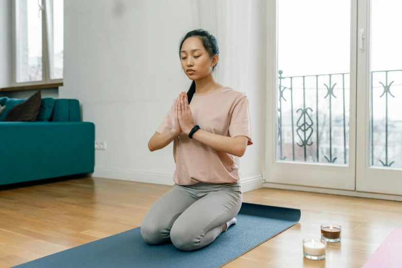 a woman sitting on a yoga mat in a living room, pexels contest winner, hurufiyya, praying posture, sydney park, low quality photo, acupuncture treatment